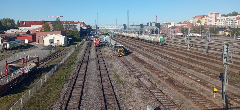 Turun tunnelmia 23.5.2022
Turun vanhan varikon / konepajan alueella yksinäinen Ex(pt?) on jäänyt jumiin seis-levyn taakse. Autovaunujen kuormausvaunu Turun vanhalta autovaunujen kuormauspaikalta on sekin jäänyt työttömäksi. Kaksi Dv12:aa odottelee työtehtäviä vieressään letka HVM:n kalustoa, johon lukeutuu mm. vuosien ajan aidan vasmmalla puolella seissyt Otso, joka on nyt edenny urallaan kolme raidetta lähemmäs keskustaa. Ratapihalla vaunuja, vanhat laiturit yhä paikoillaan. Pian alkavat työt, joissa koko asema menee kerta kaikkiaan uusiksi.
Avainsanat: op_HVM;op_VR;jyv_XOe;jyv_Dv12;jyv_Tka7;jyv_Ein;jyv_Vgobo