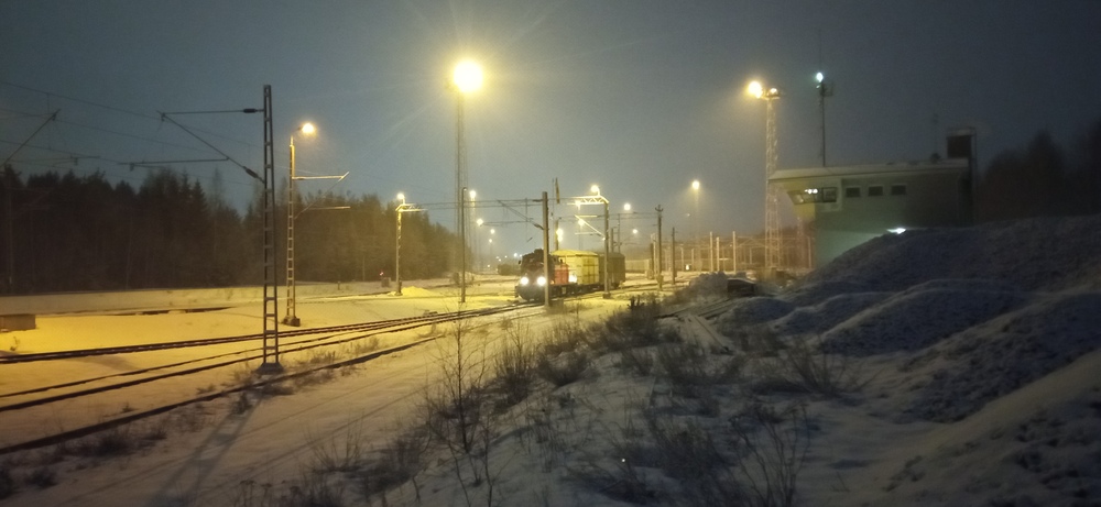Talvi-ilta Riihimäen ratapihalla 28.1.2023
Riihimäen päivystäjän virkaa toimittava Dv12 murisee vanhassa laskumäessä puskiessaan umpivaunuja Riihimäki lajittelun raiteille.
Avainsanat: op_VR;jt_Vaihtotyö;jyv_Dv12;jyv_Gbln;jyv_Gbls;päivystäjä_Riihimäki;infra_laskumäki