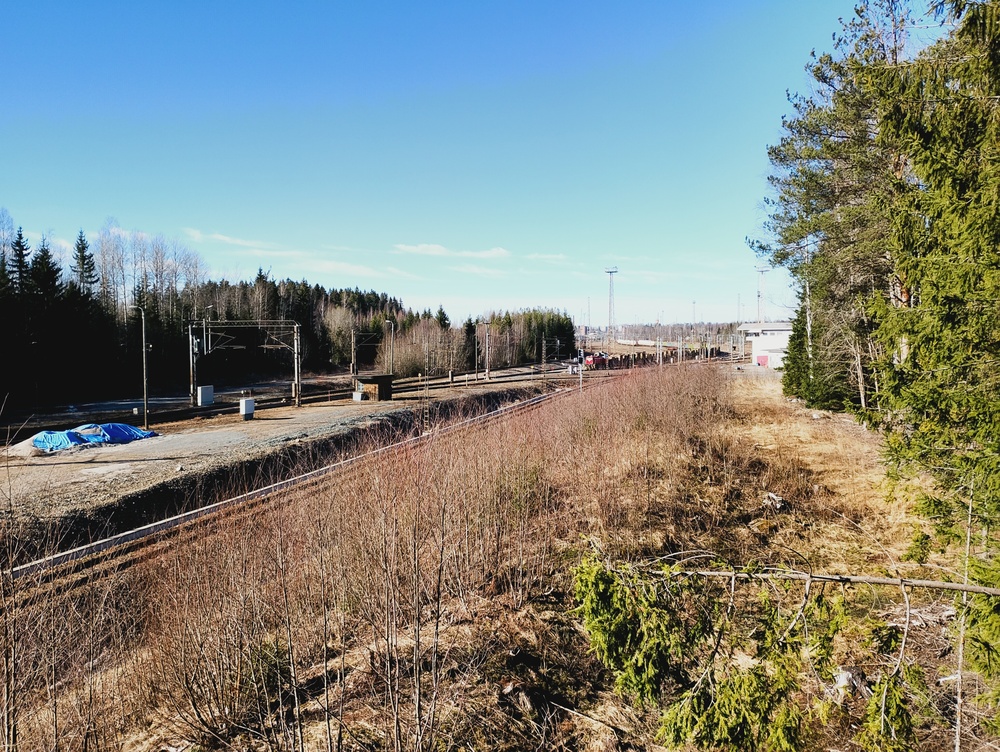 Riihimäki lajittelu etelästä 20.3.2026
Näkymä Riihimäen lajitteluratapihalle sen eteläpuoliselta mäeltä. Vasemmalle erkanee raide Raasu qlin terminaalille. Ratapihalla näkyy Riihimäen päivystäjänä työskentelevä Dv12 painamassa juuri Raasulista noutamaansa raakapuuletkaa alas vanhaa laskumäkeä pitkin samoin kuin joitain muitakin raakapuuletkoja, Yaran käyttämiä säiliövaunuja sekä oletettavasti lähinnä Puolustusvoimien kuljetuksissa käytettäviä avovaunuja.
Avainsanat: op_VR;jt_Vaihtotyö;jyv_Dv12;jyv_Sp;jyv_Sps;infra_laskumäki;päivystäjä_Riihimäki