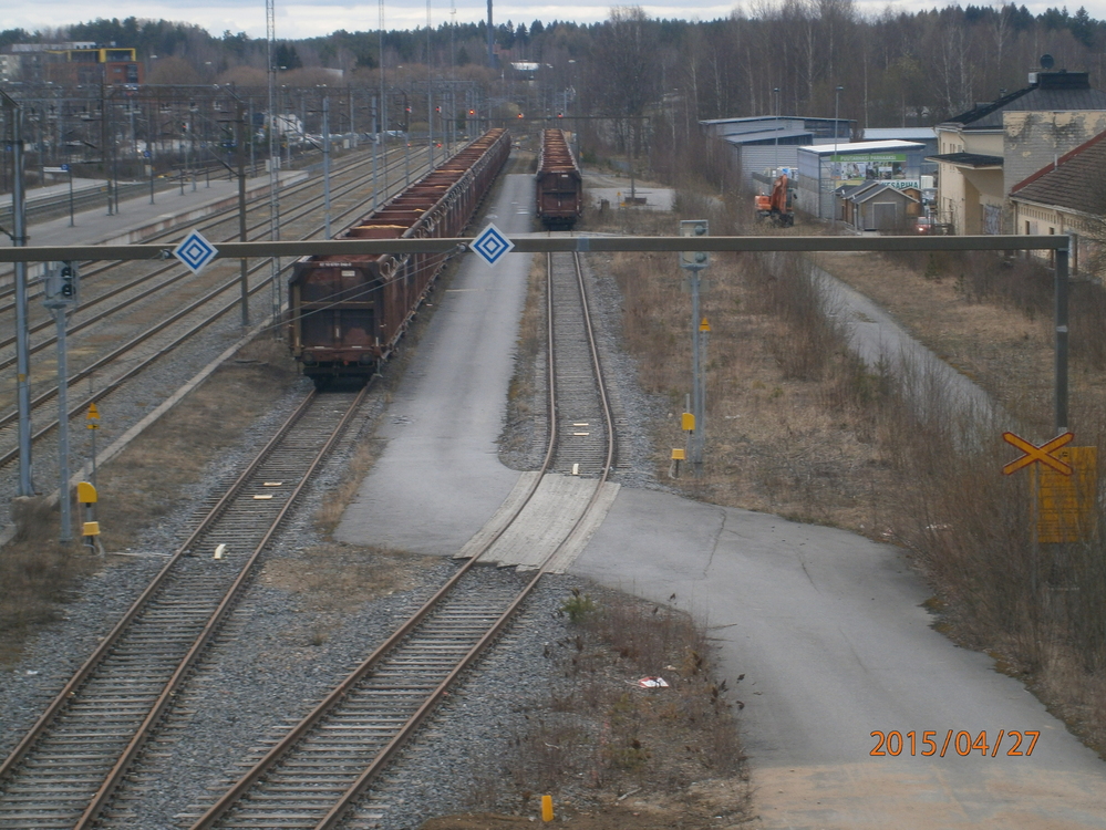 Mikkelin ratapihaa 27.4.2015
Käytöstä pois jääneillä raakapuunkuormausraiteilla seisoo hakevaunuja. Makasiinien eteen mennyt seis-levytettynä ollut raide on kadonnut ja sen paikalla seisoo kiskopyöräkaivinkone.
Jokseenkin tuhlaukselta tuntuu, että puunkuormauspaikka, jolla vaihtotöiden tekeminen sähköllä on mahdollistettu seisoo vailla käyttöä.
Avainsanat: op_VR;jyv_Fakks;kiskopyöräkaivinkone