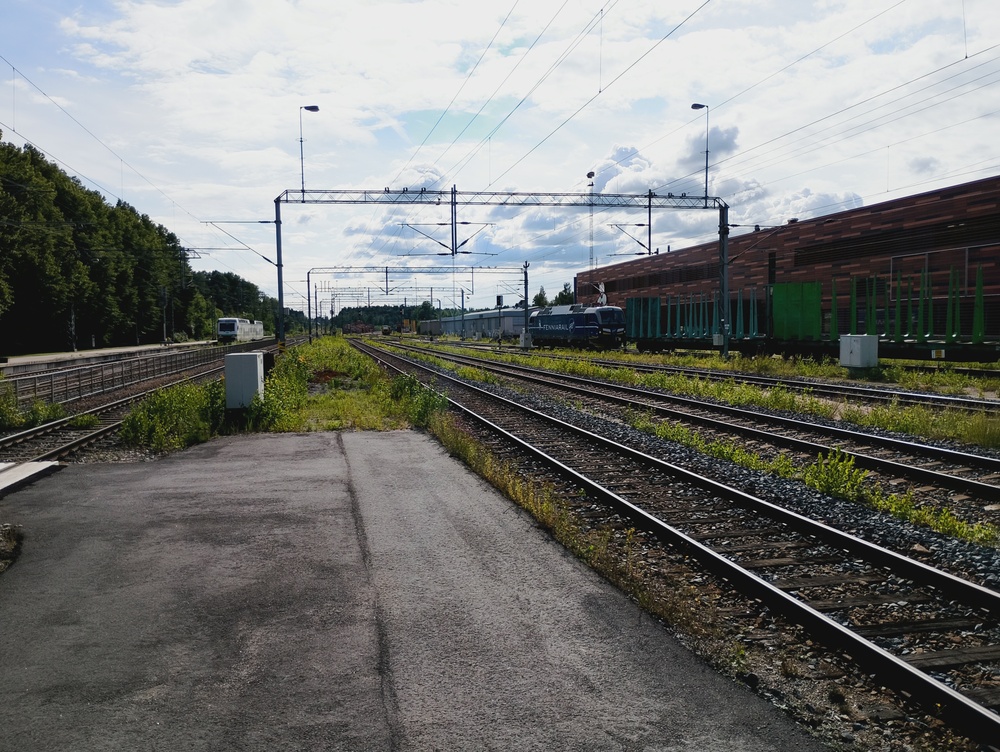 Vaihtotöitä Karjaalla 22.7.2026 #1
Fenniarailin Sr3 on juuri saanut tyhjän raakapuujunan tuotua määräasemalleen ja aloittelee nyt vaihtotöitä kiertämällä ensin junan toiseen päähän.
Vasemmalla Sm4 odottelee seuraavaa Hangon reissuansa.
Avainsanat: op_Fenniarail;op_VR;jt_Tavarajuna;jt_Raakapuujuna;jt_Vaihtotyö;jyv_Sr3;jyv_Vocp;jyv_Sm4