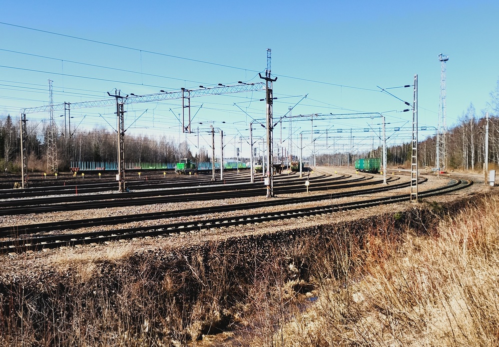 Riihimäki lajittelu 24.3.2026
Kevätpäivä Riihimäen ratapihalla. Riihimäen päivystäjä kerää letkaa Raasuliin vietäväksi, koukussa on tyhjiä raakapuuvaunuja sekä hieman yllättävästi Kbp ja Rmm, jotka päätyivät lastauslaiturin luokse kuormattavaksi. Ettei olisi Puolustusvoimien kuljetuksesta ollut kyse?
Sr1:n vetämä kiskojuna Kaipiaisten kiskohitsaamolta on pysähtynyt jättämään puolet vaunuísta Riihimäen ratapihalle, loppujen kanssa jatketaan Karjaalle.
Avainsanat: op_VR;jt_Tavarajuna;jt_Vaihtotyö;jyv_Sr1;jyv_Dr19;jyv_Sp;jyv_Sps;jyv_Vop;päivystäjä_Riihimäki