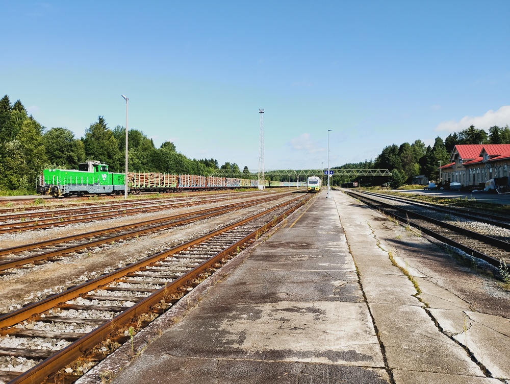 Kesäaamu Haapamäellä 31.7.2026
Dr19 kasaa lähtevää raakapuujunaa Tampere-Keuruu -kiskobussin vaihtaessa suuntaa. Raiteisto on nykyiseen tarpeeseen nähden lievästi ylimitoitettua.
Avainsanat: op_VR;jt_Vaihtotyö;jt_Matkustajajuna;jt_Kiskobussi;jyv_Dr19;jyv_Dm12;jyv_Sps;jyv_Sp;juna_Haapamäkeläinen